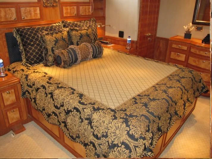 a bed with a blue and yellow comforter aboard AUSTRALIS Yacht for Sale