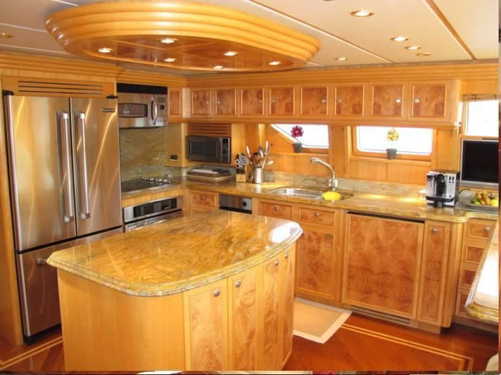 a kitchen with a stainless steel refrigerator aboard AUSTRALIS Yacht for Sale