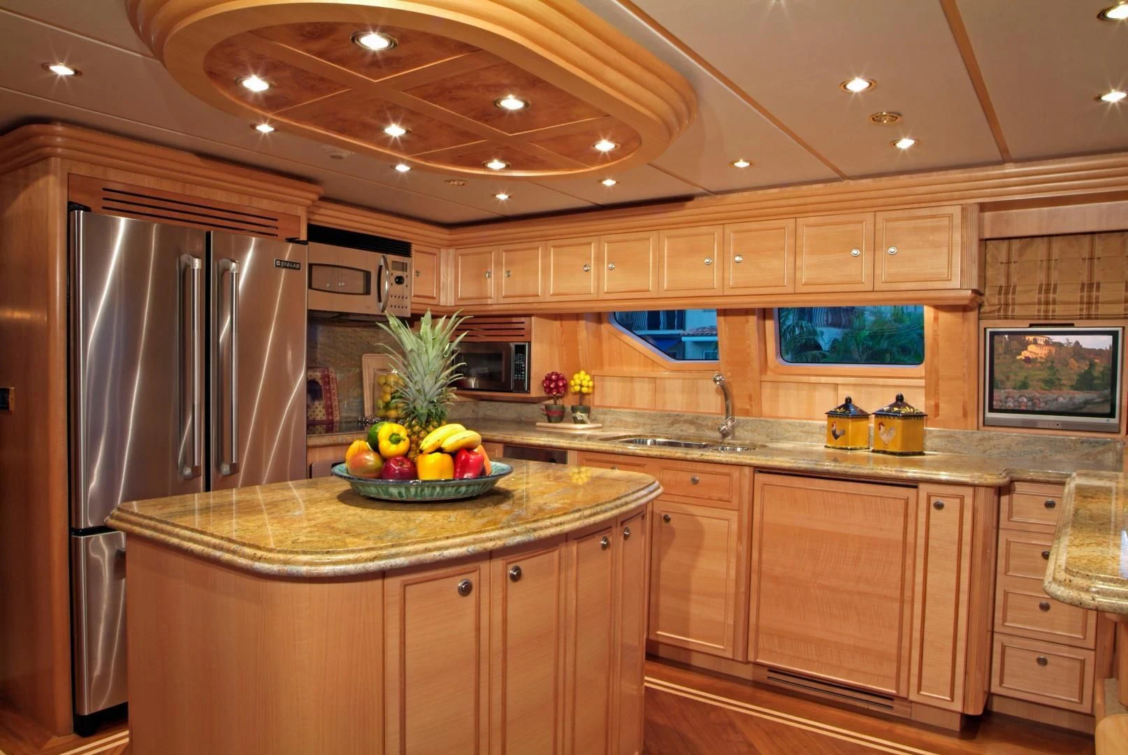 a kitchen with a stainless steel refrigerator aboard AUSTRALIS Yacht for Sale