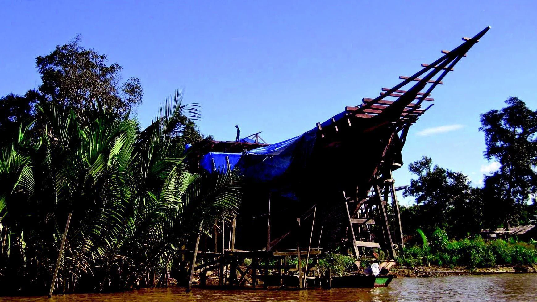 a large tree house with a blue roof and a blue sky aboard DUNIA BARU Yacht for Charter