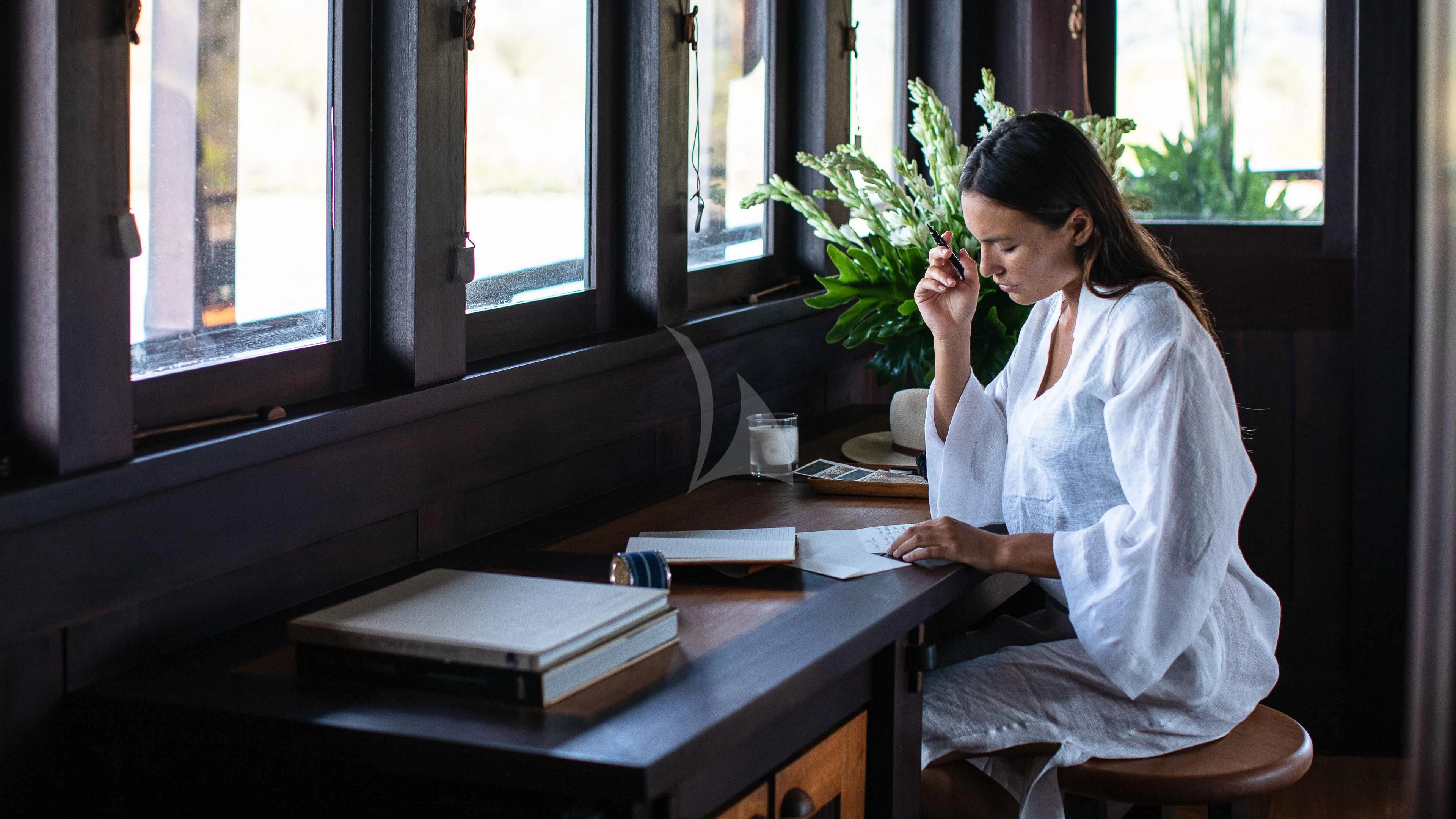 a person sitting at a desk aboard DUNIA BARU Yacht for Charter