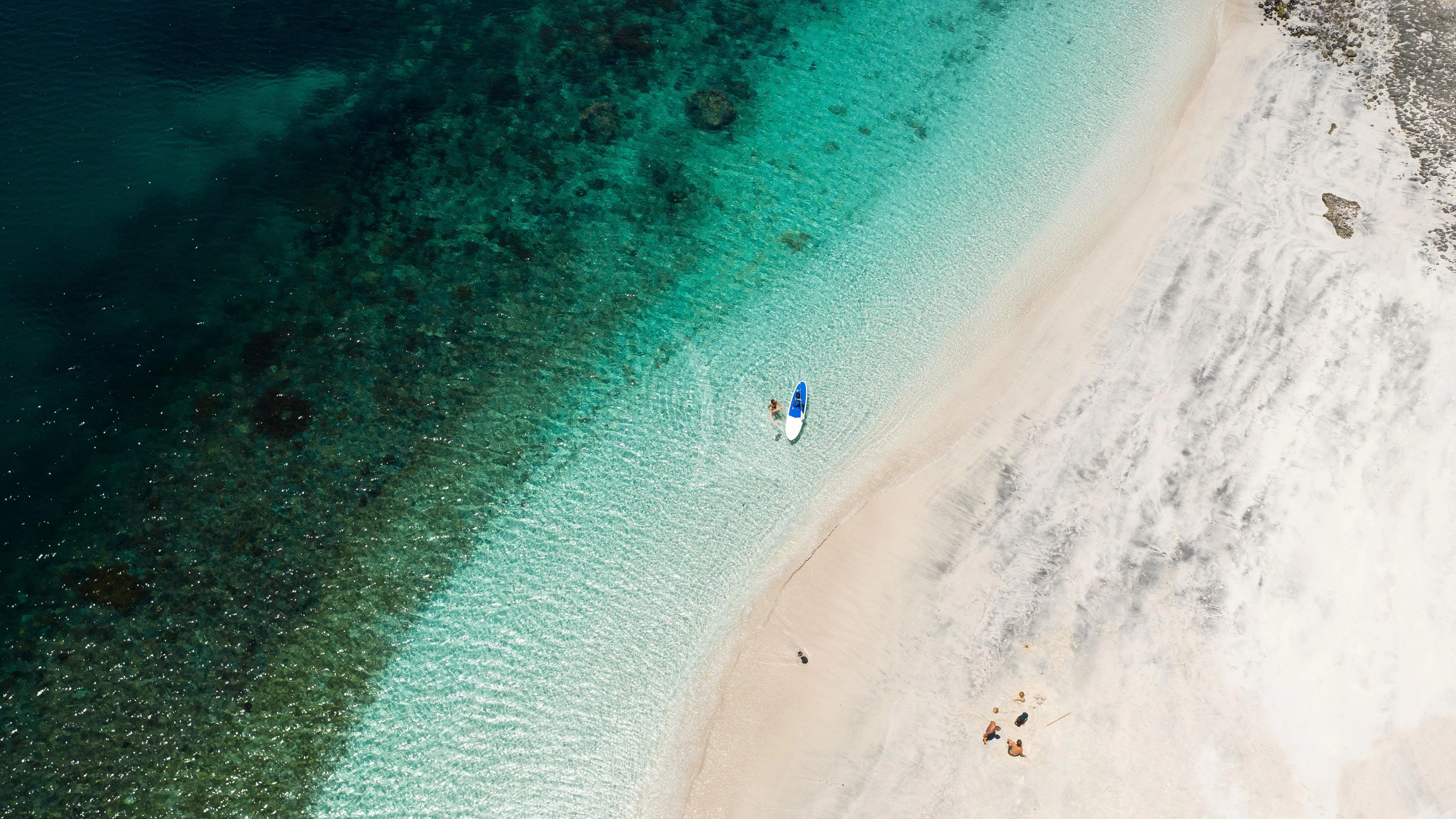 a person walking on a beach aboard DUNIA BARU Yacht for Charter