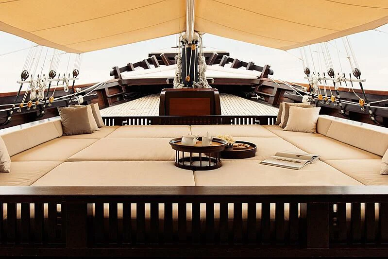 a room with a couch and a table with a lamp on it aboard DUNIA BARU Yacht for Charter