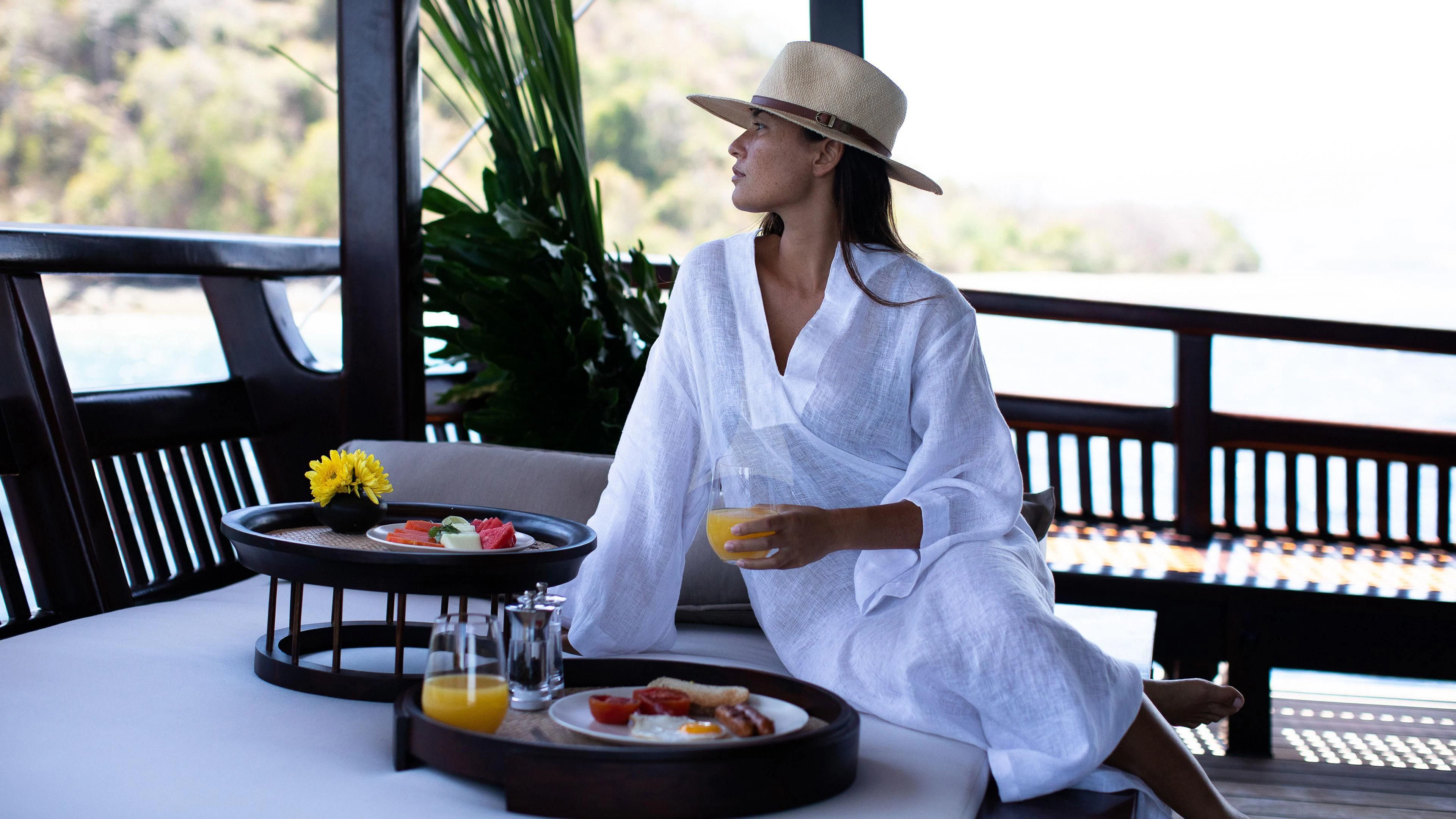 a person sitting at a table with a plate of food aboard DUNIA BARU Yacht for Charter