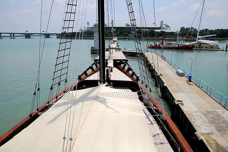 a large white boat in a harbor aboard DUNIA BARU Yacht for Charter