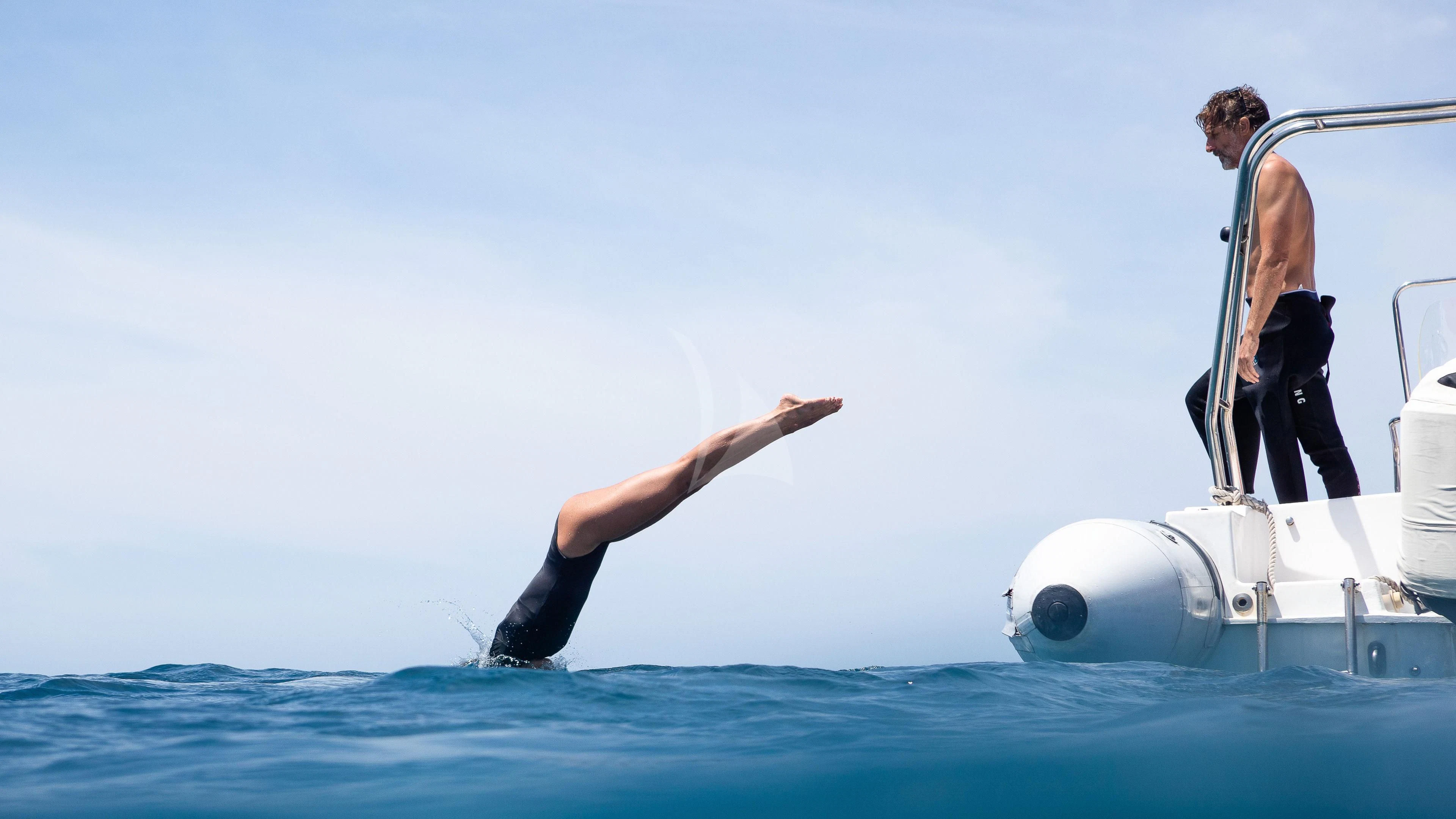a man jumping out of a boat aboard DUNIA BARU Yacht for Charter