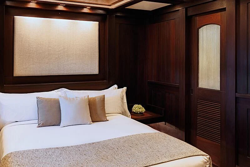 a bed with white sheets and pillows aboard DUNIA BARU Yacht for Charter
