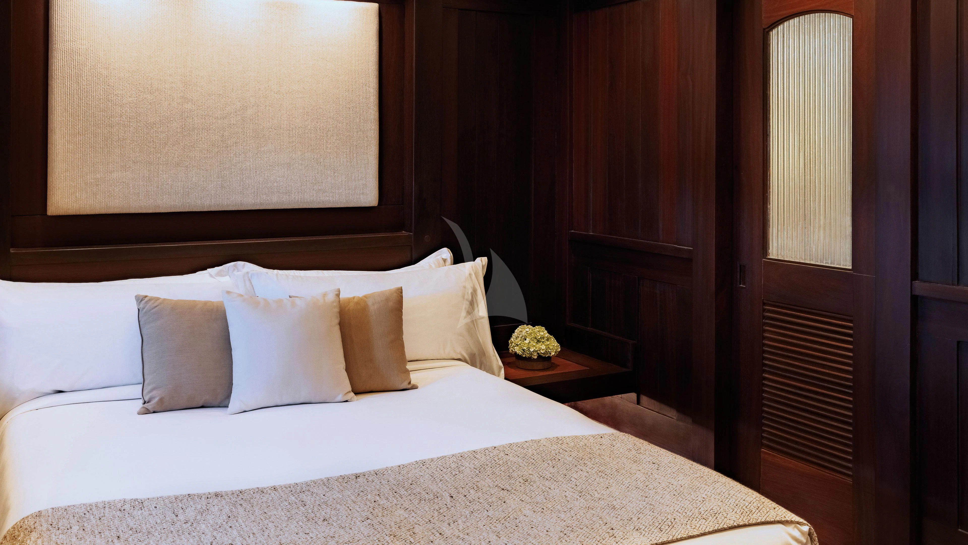 a bed with white sheets and pillows aboard DUNIA BARU Yacht for Charter