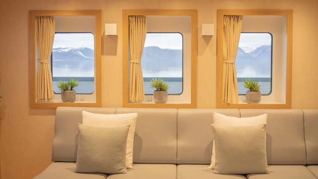 a living room with a couch and a window aboard KALM Yacht for Sale