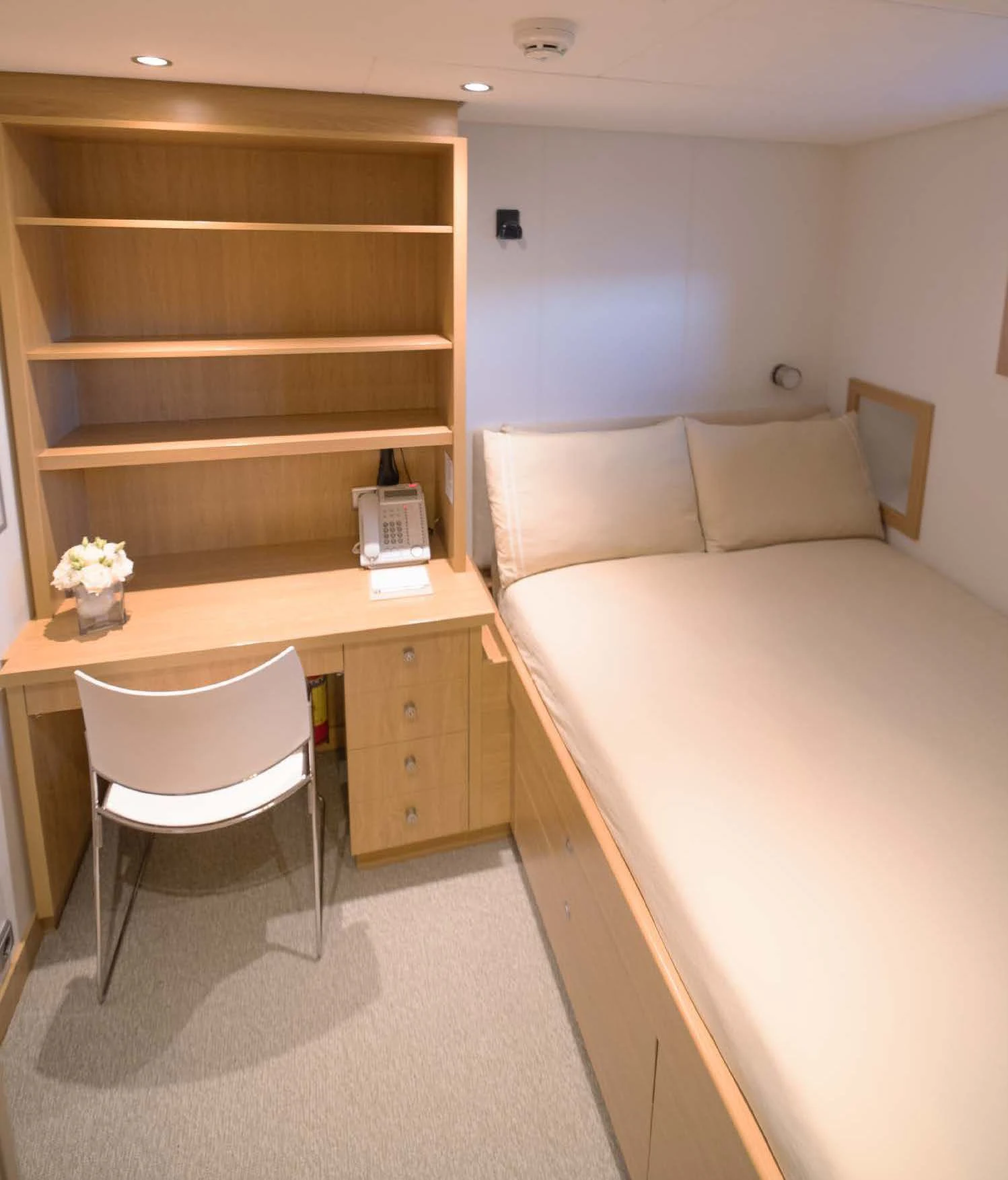 a bedroom with a desk and a bed aboard KALM Yacht for Sale