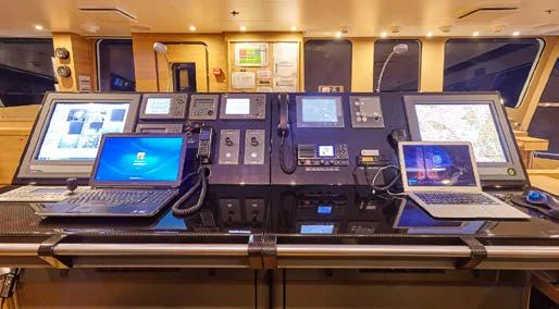 laptops and other laptops on a table aboard KALM Yacht for Sale