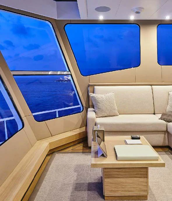 a room with a couch and a table and a window aboard KALM Yacht for Sale