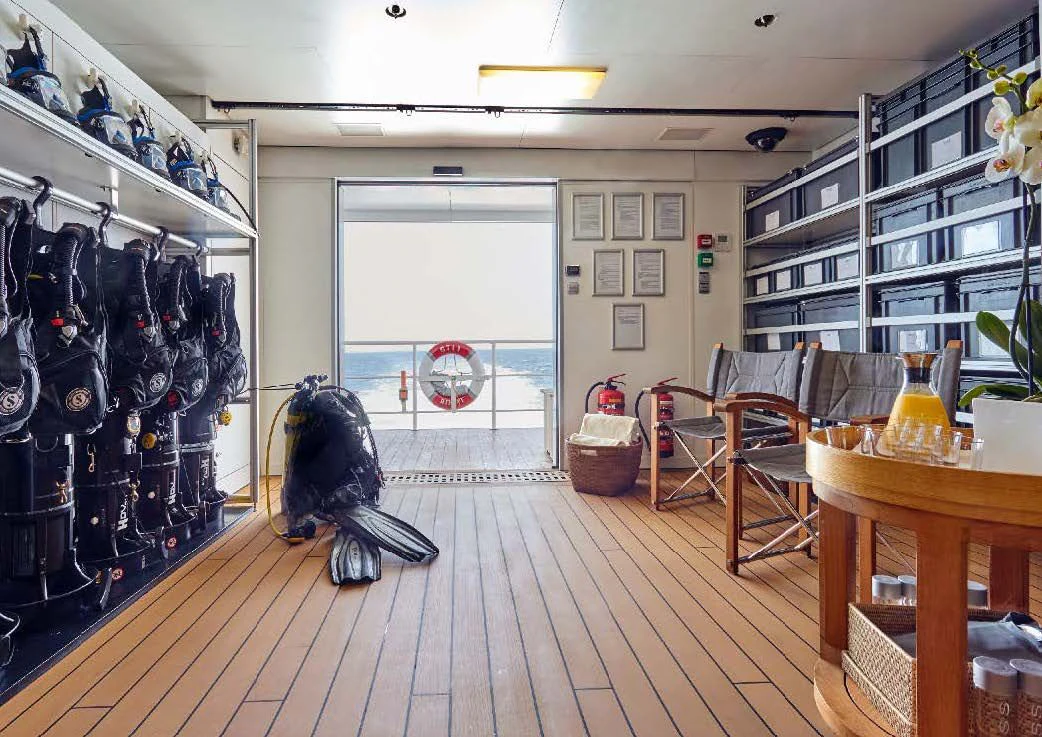a room with a wood floor and shelves and a large window with a wood floor and a wood aboard KALM Yacht for Sale