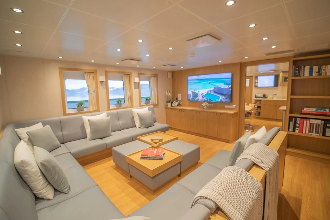 a living room with a large screen aboard KALM Yacht for Sale
