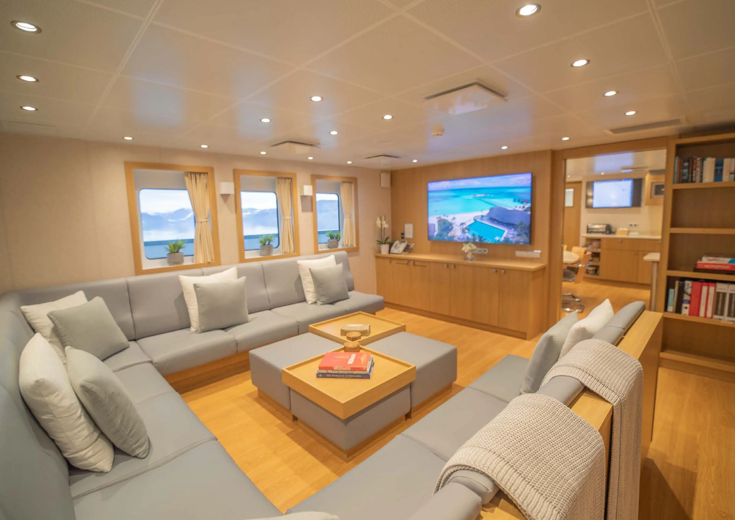 a living room with a large screen aboard KALM Yacht for Sale