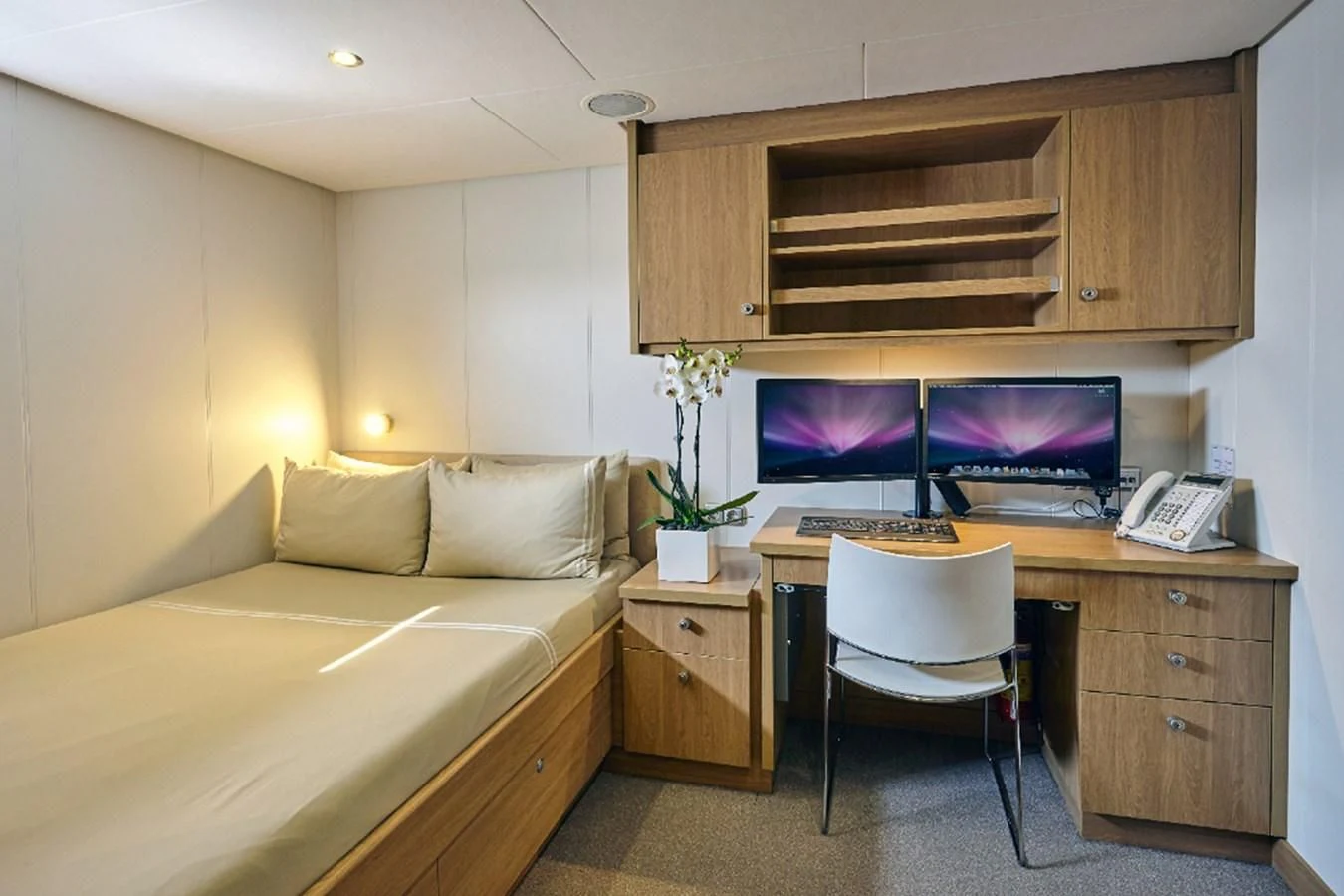 a living room with a bed and a desk aboard KALM Yacht for Sale