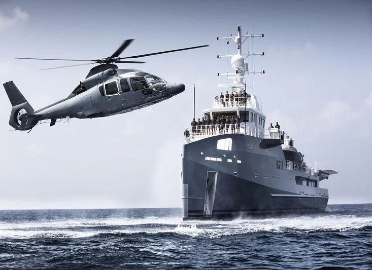 a helicopter flying over a ship aboard KALM Yacht for Sale
