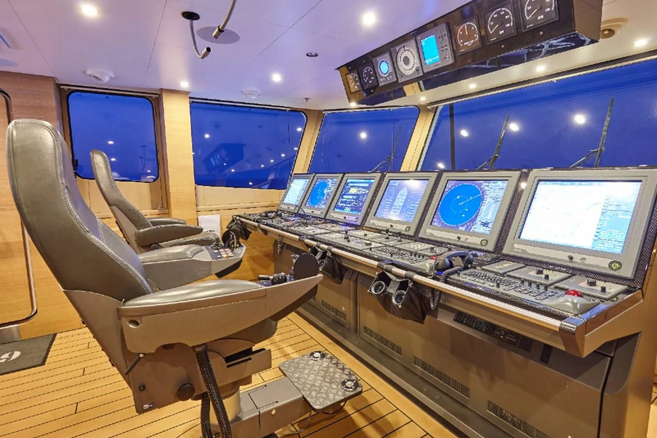 a control room with several computers aboard KALM Yacht for Sale