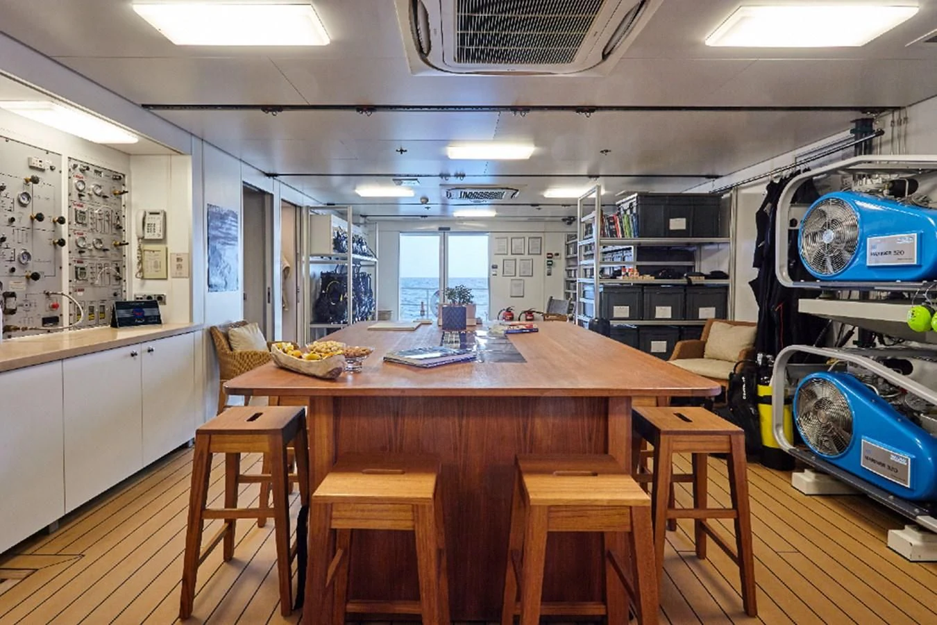 a room with tables and chairs aboard KALM Yacht for Sale