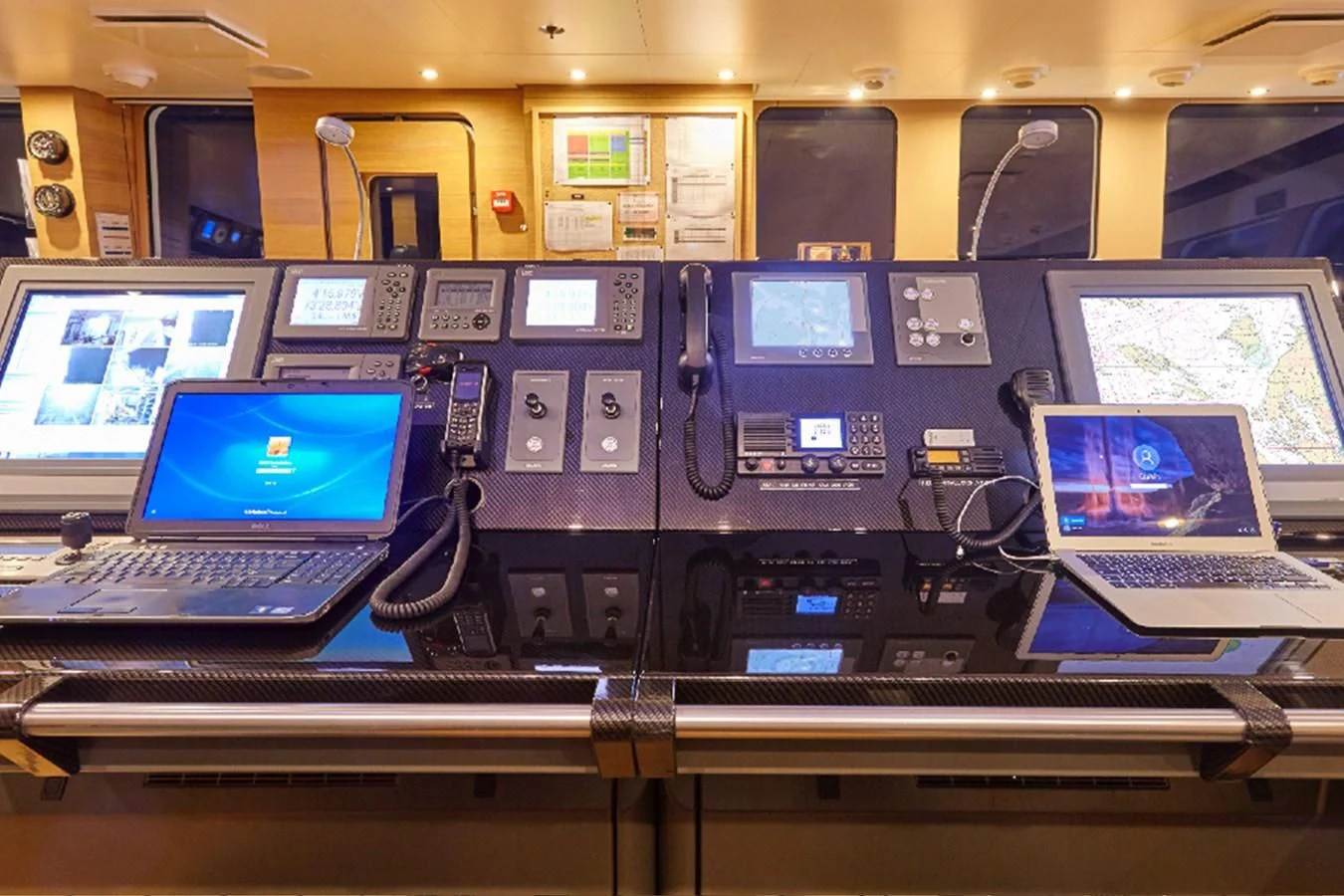 laptops and electronic devices on a table aboard KALM Yacht for Sale