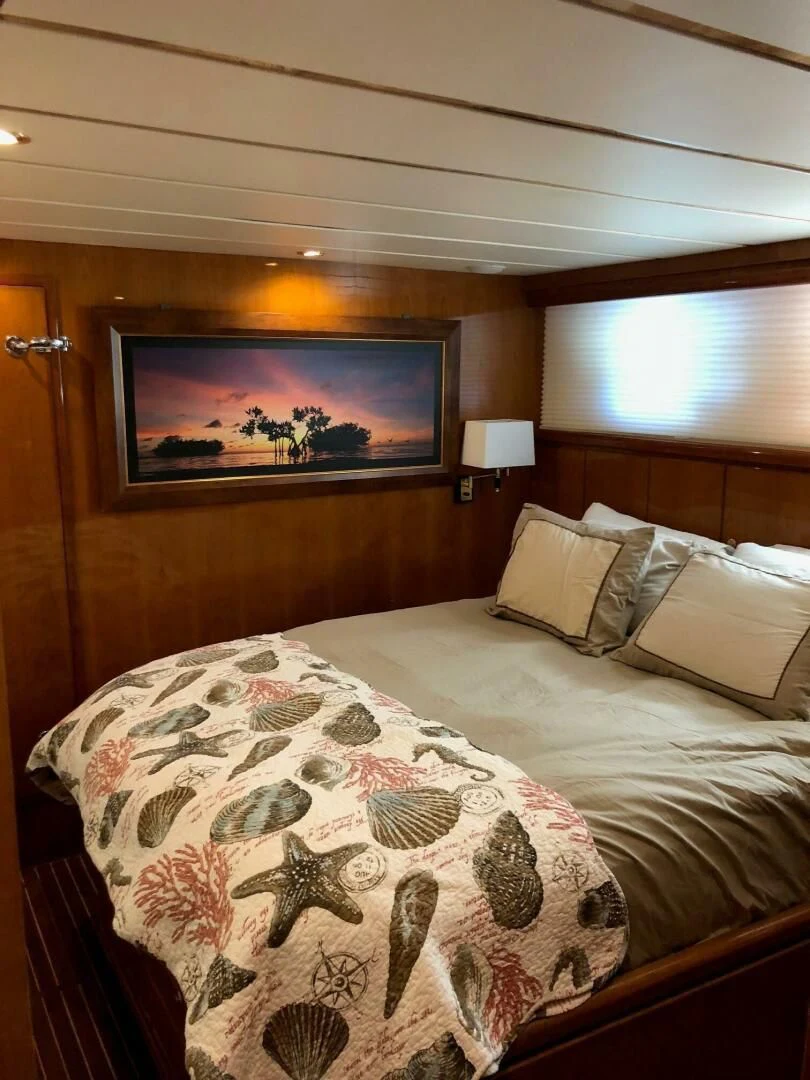 a bed with a floral blanket aboard TORTUGA Yacht for Sale