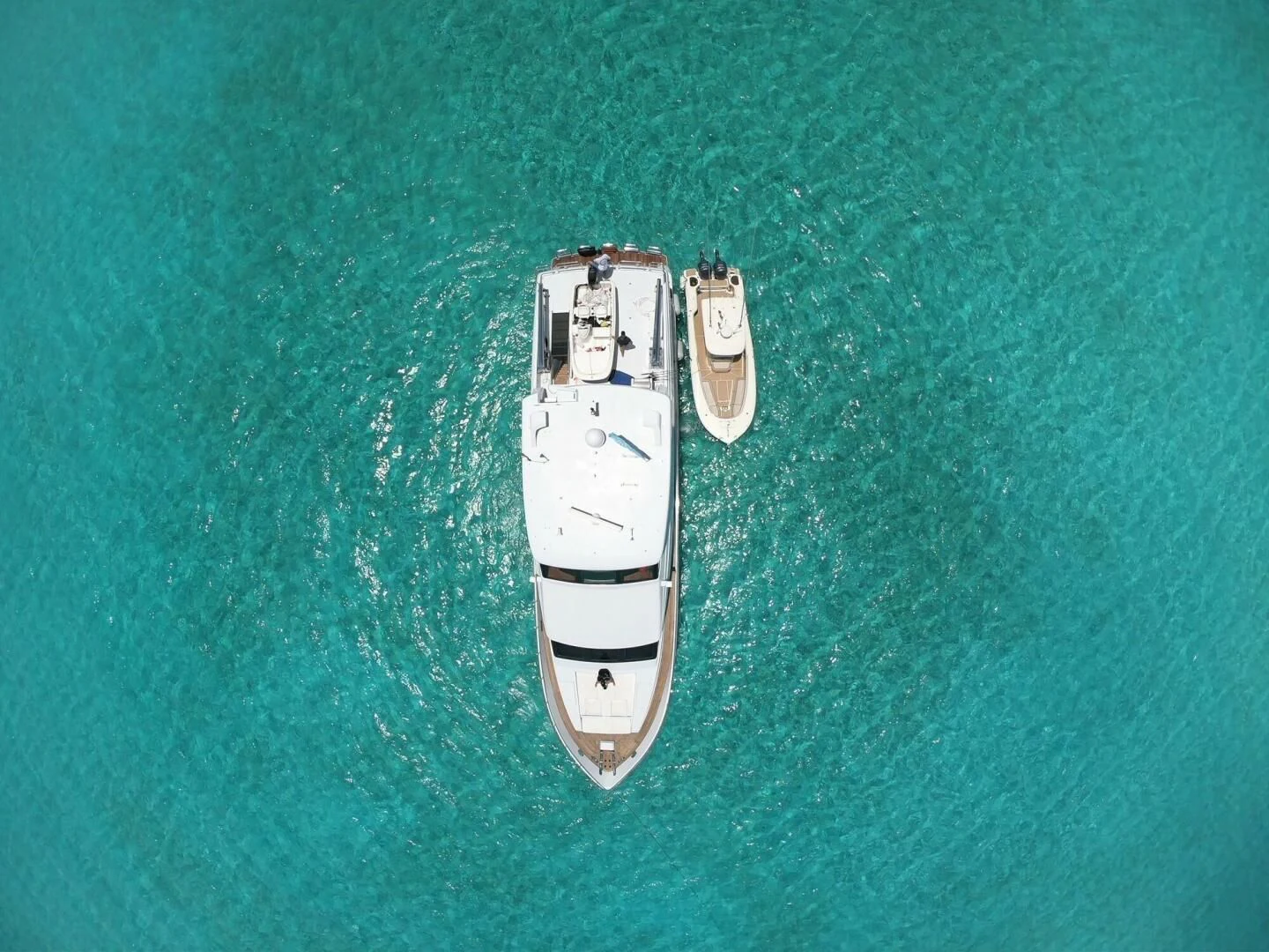 a white boat on a body of water aboard TORTUGA Yacht for Sale