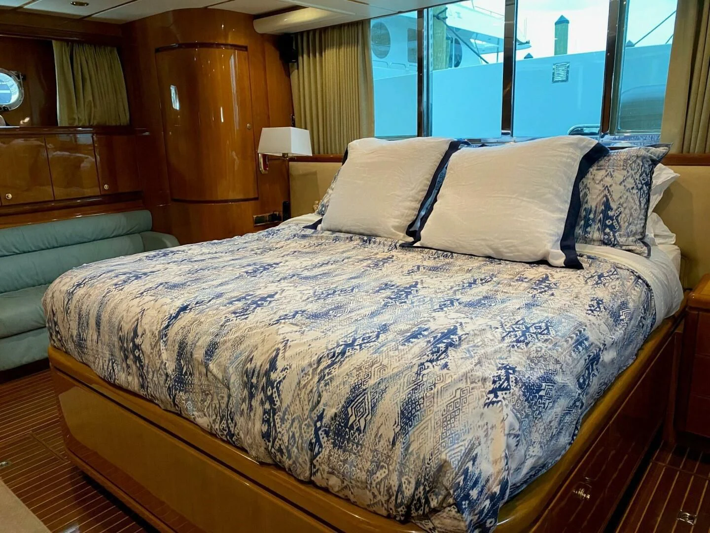 a bed with a blue comforter aboard TORTUGA Yacht for Sale