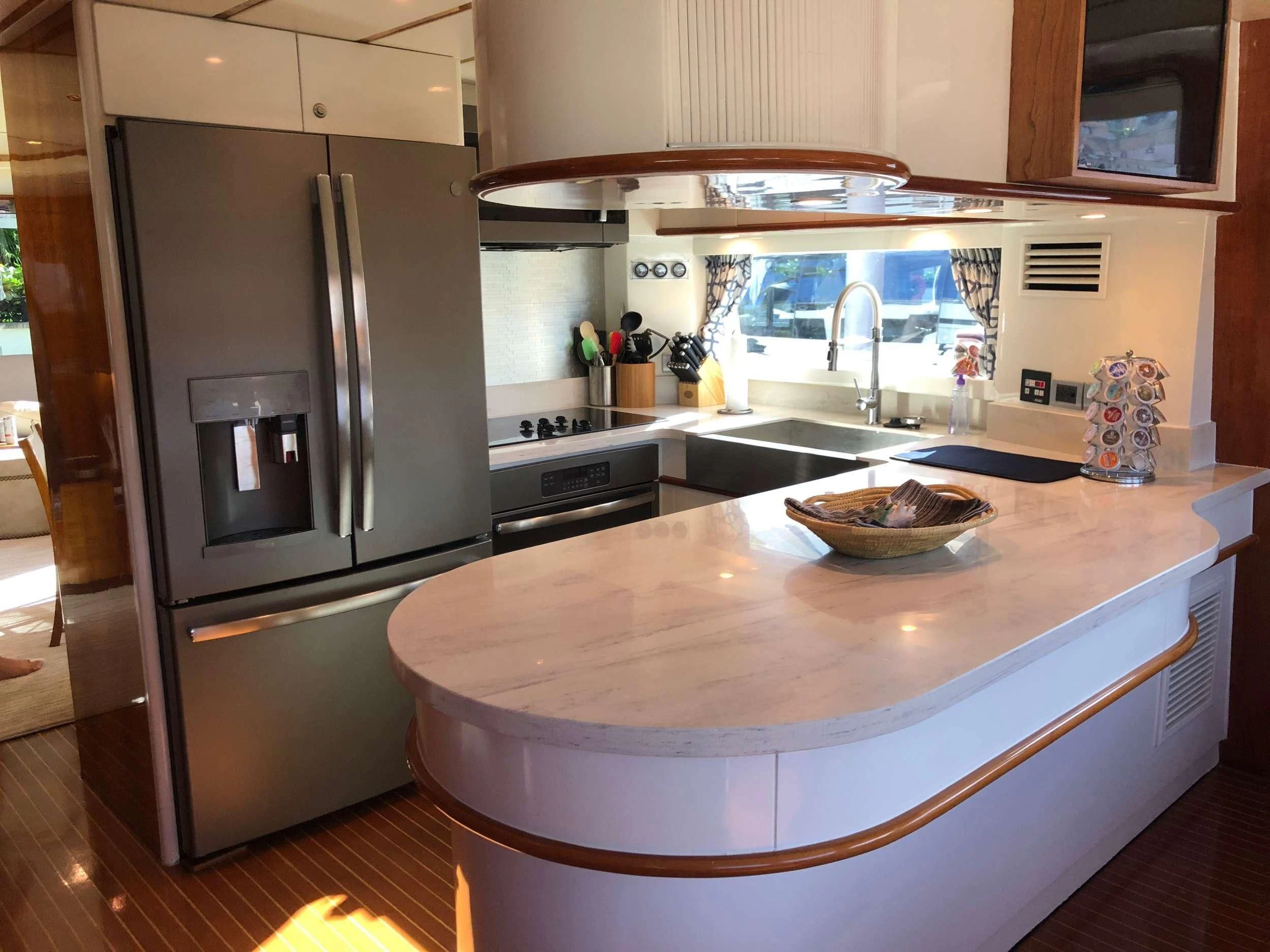 a kitchen with a stainless steel refrigerator aboard TORTUGA Yacht for Sale