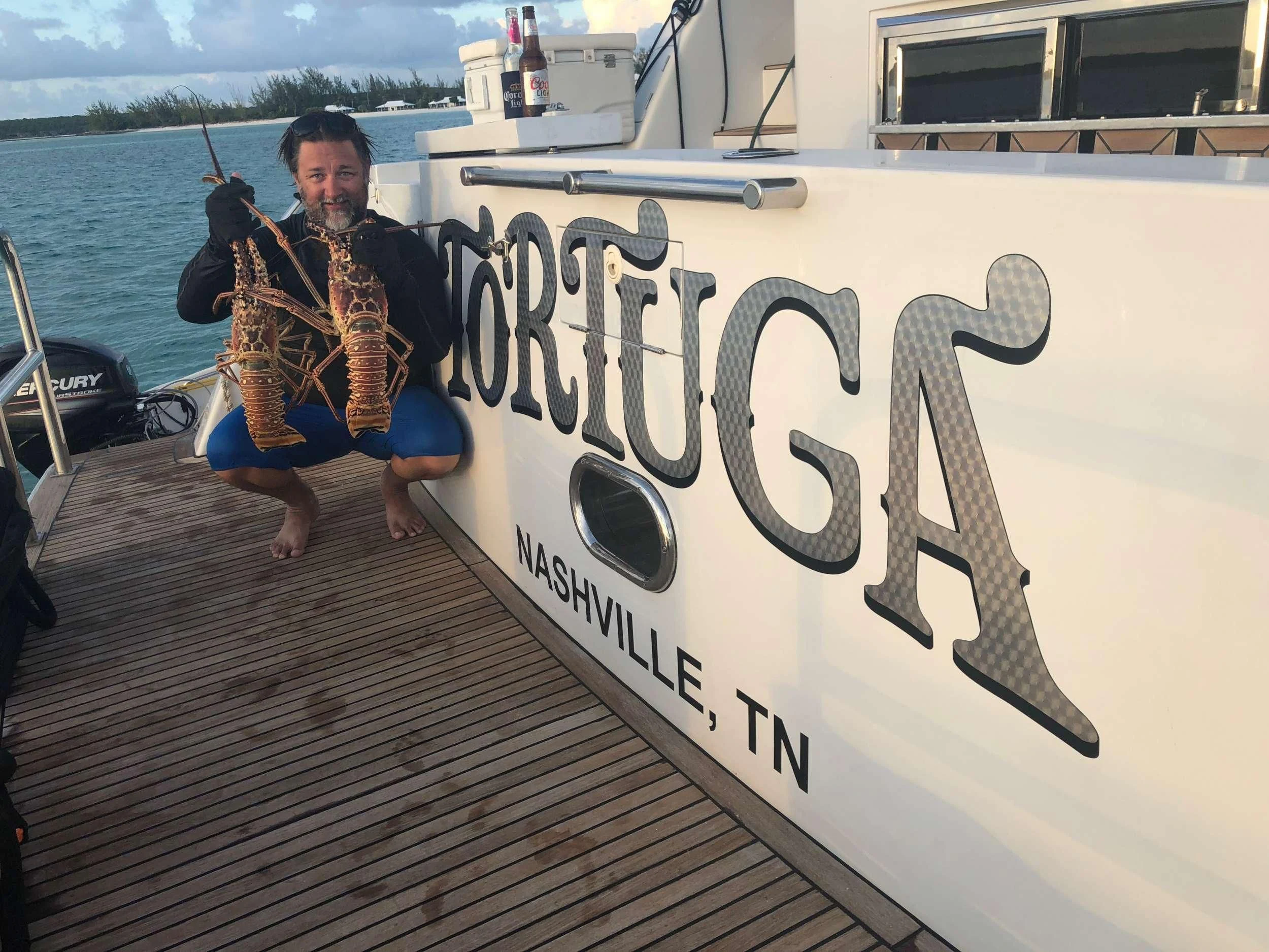 a person sitting on a boat holding a guitar aboard TORTUGA Yacht for Sale