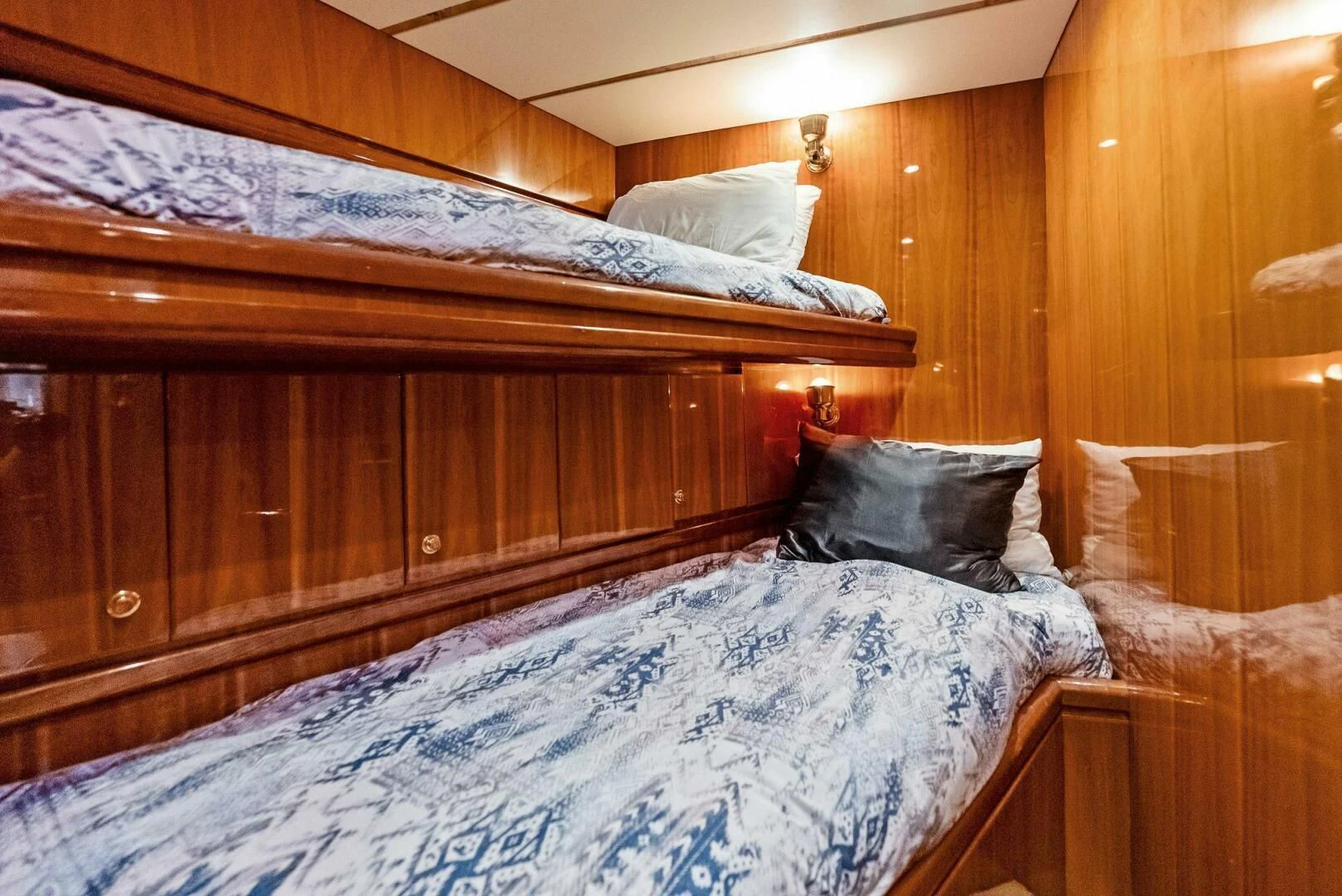 a bed with a wooden headboard aboard TORTUGA Yacht for Sale