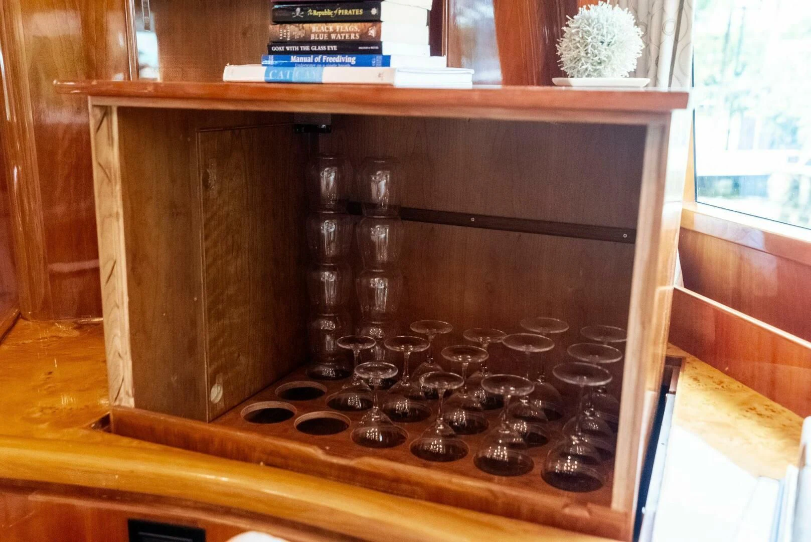 a wooden cabinet with a black knob aboard TORTUGA Yacht for Sale