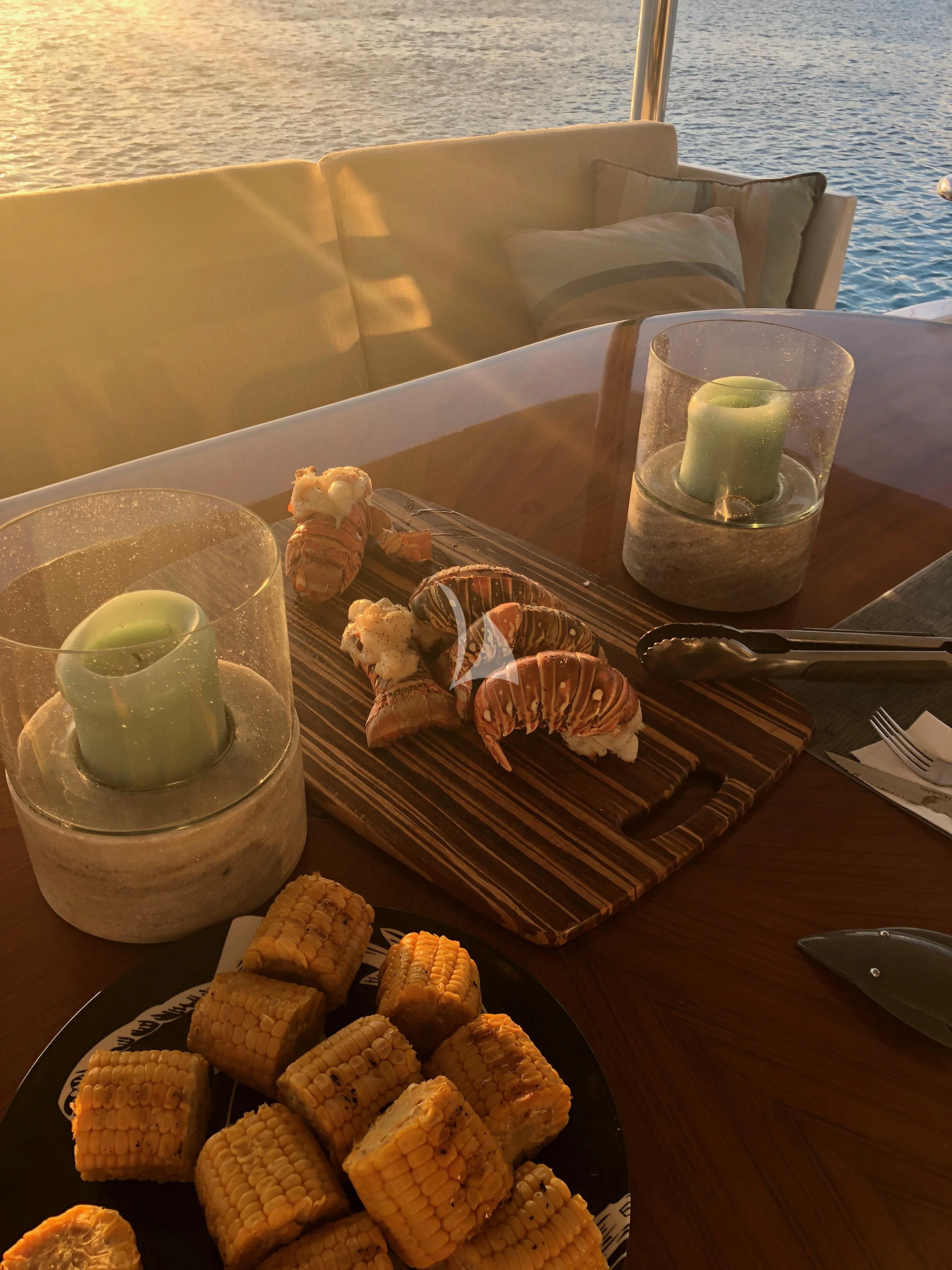 a tray of food and a glass of water aboard TORTUGA Yacht for Sale