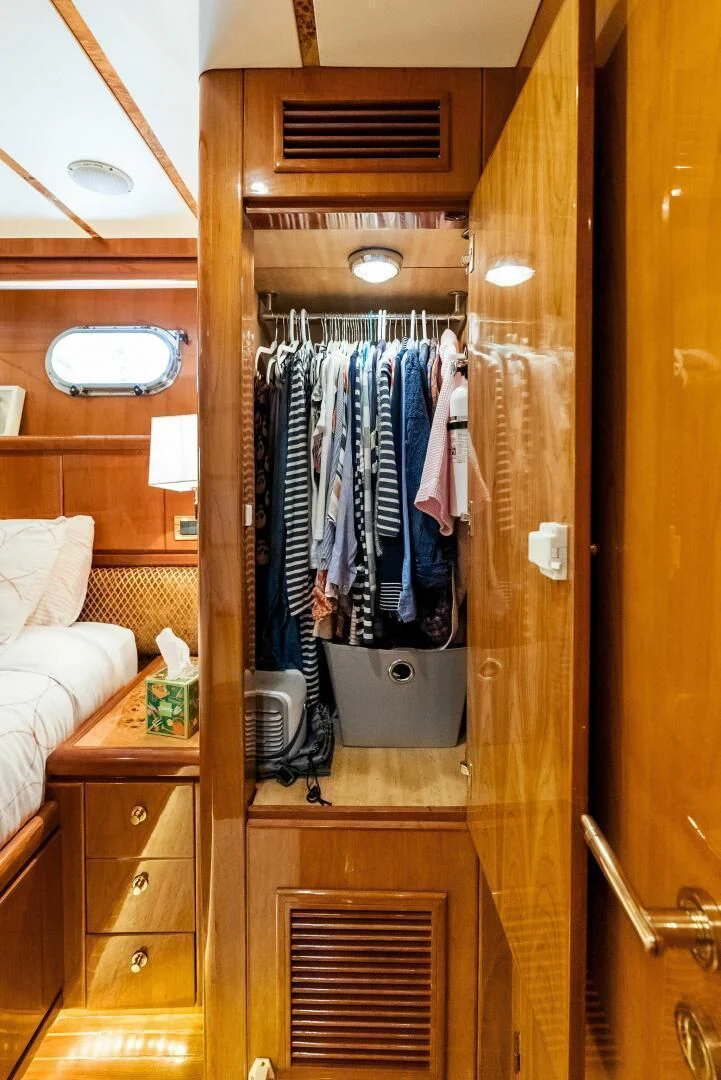 a closet with clothes on the door aboard TORTUGA Yacht for Sale