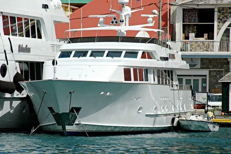 a large white boat in a harbor aboard CONTRARIAN ROSE Yacht for Sale