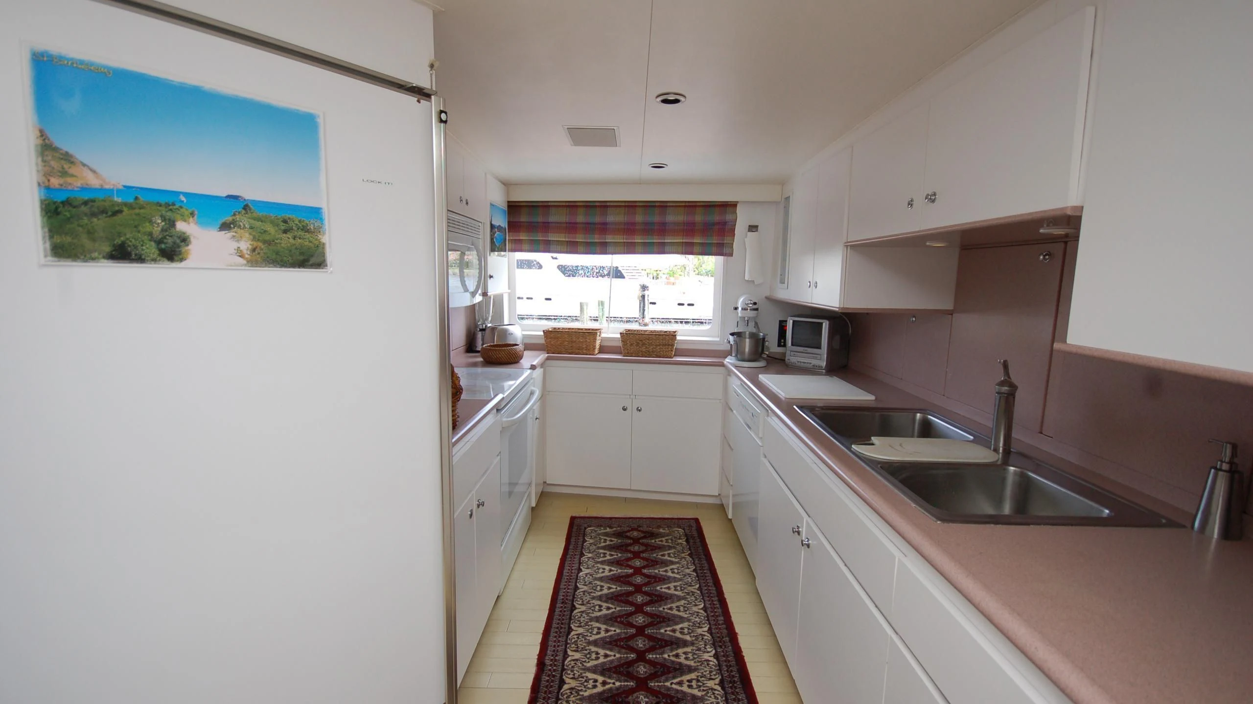 a kitchen with a red rug aboard CONTRARIAN ROSE Yacht for Sale