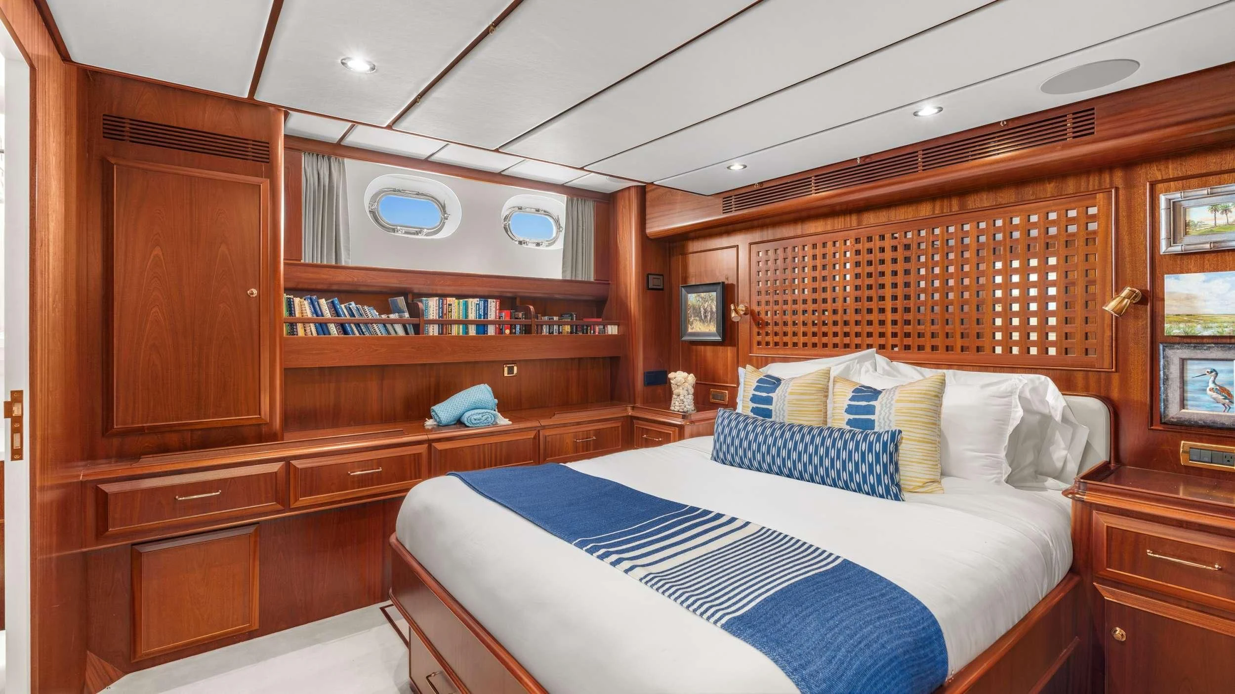 a bedroom with a bed and a bookcase aboard ABIDE Yacht for Sale