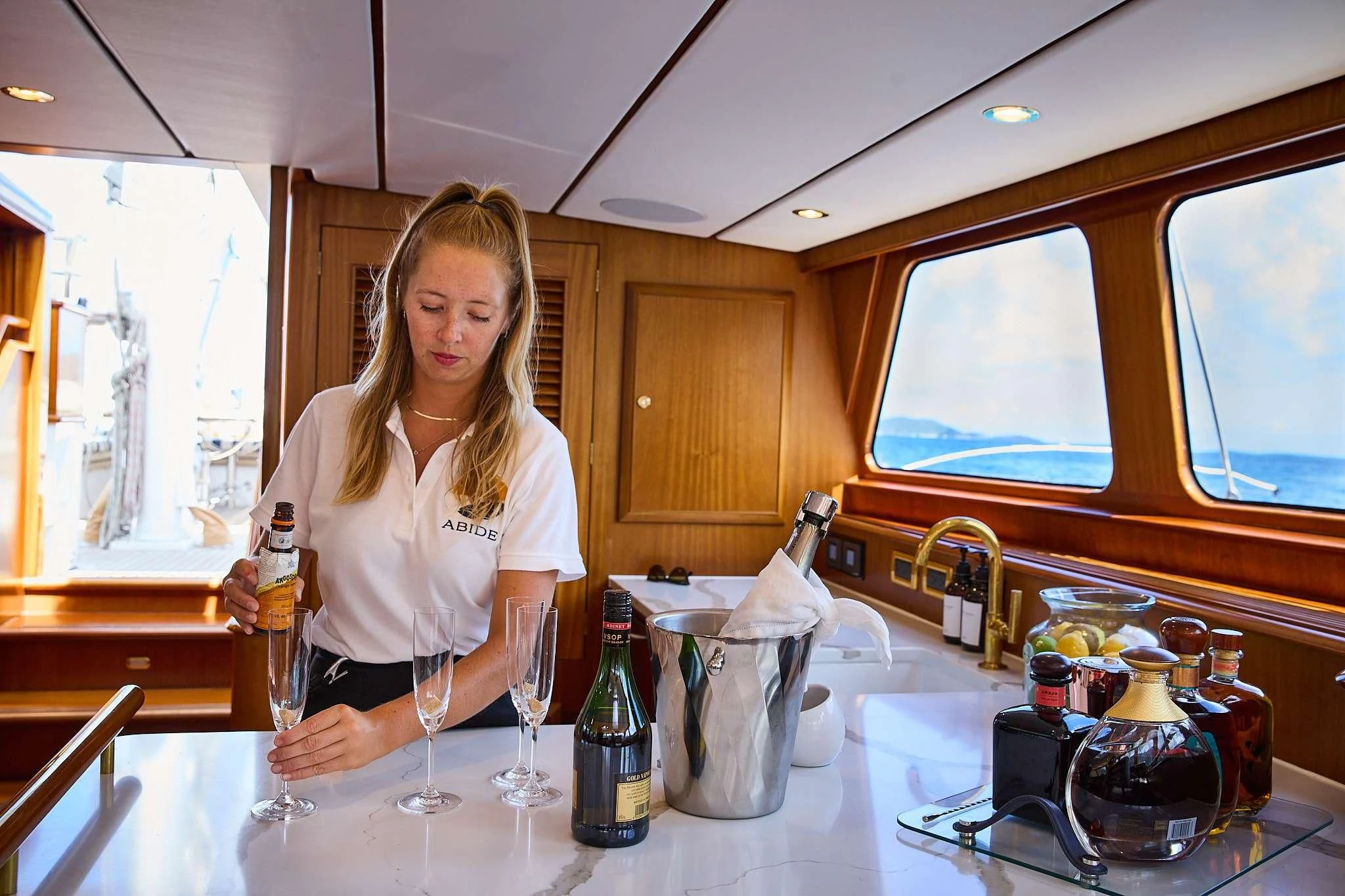 a person pouring a glass of wine aboard ABIDE Yacht for Sale