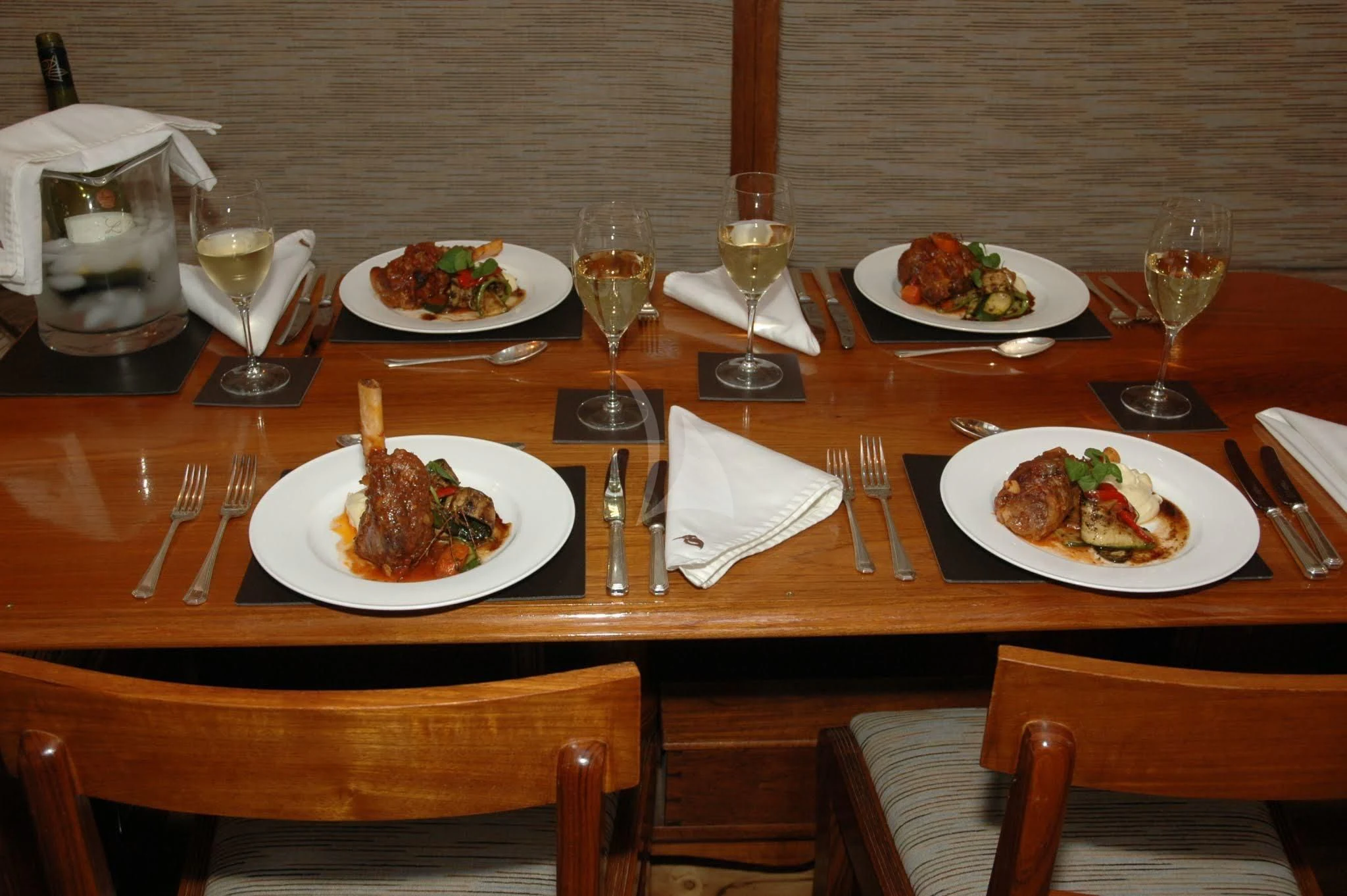 a table with plates of food and glasses on it aboard HALCYON Yacht for Sale