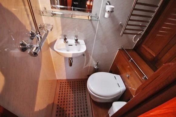 a bathroom with a toilet sink and a mirror aboard HALCYON Yacht for Sale