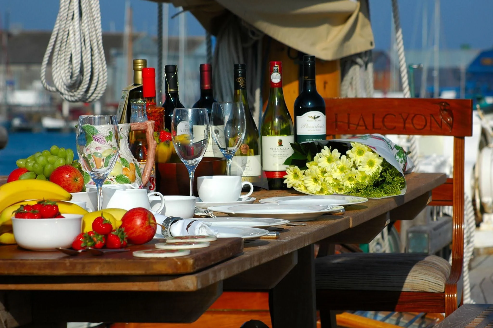 a table with food and wine bottles aboard HALCYON Yacht for Sale