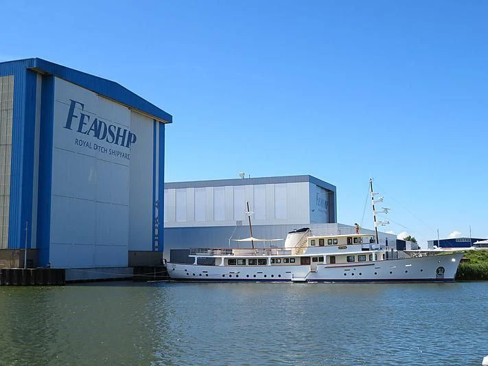 a large white boat next to a building aboard ISTROS Yacht for Sale