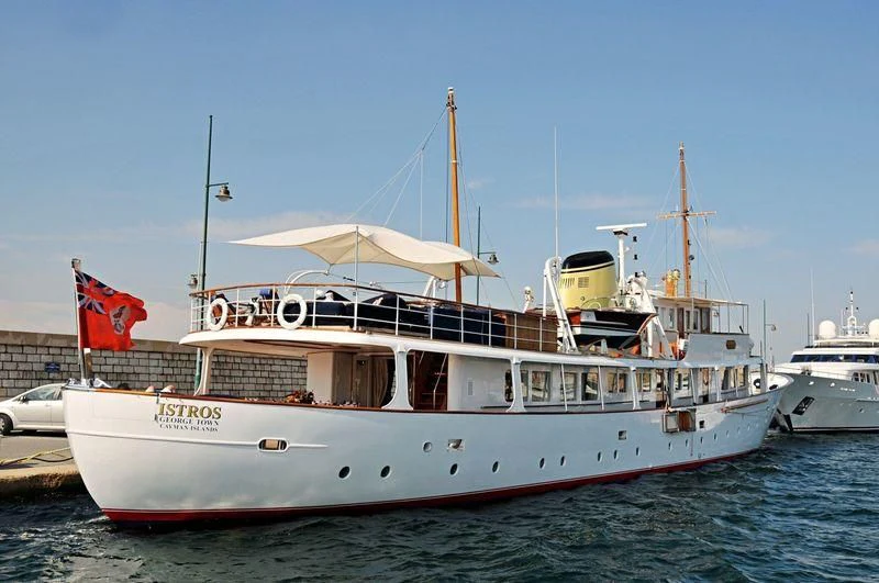 a large white boat with flags aboard ISTROS Yacht for Sale