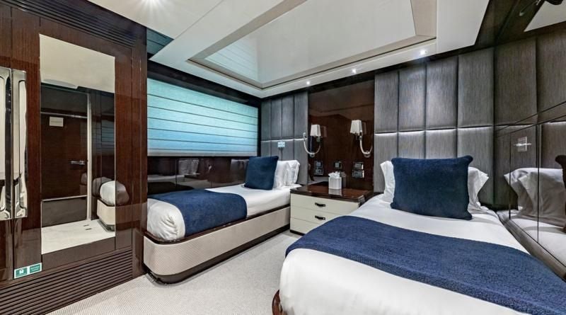 a room with beds and a mirror aboard CAPTAIN MORGAN III Yacht for Sale