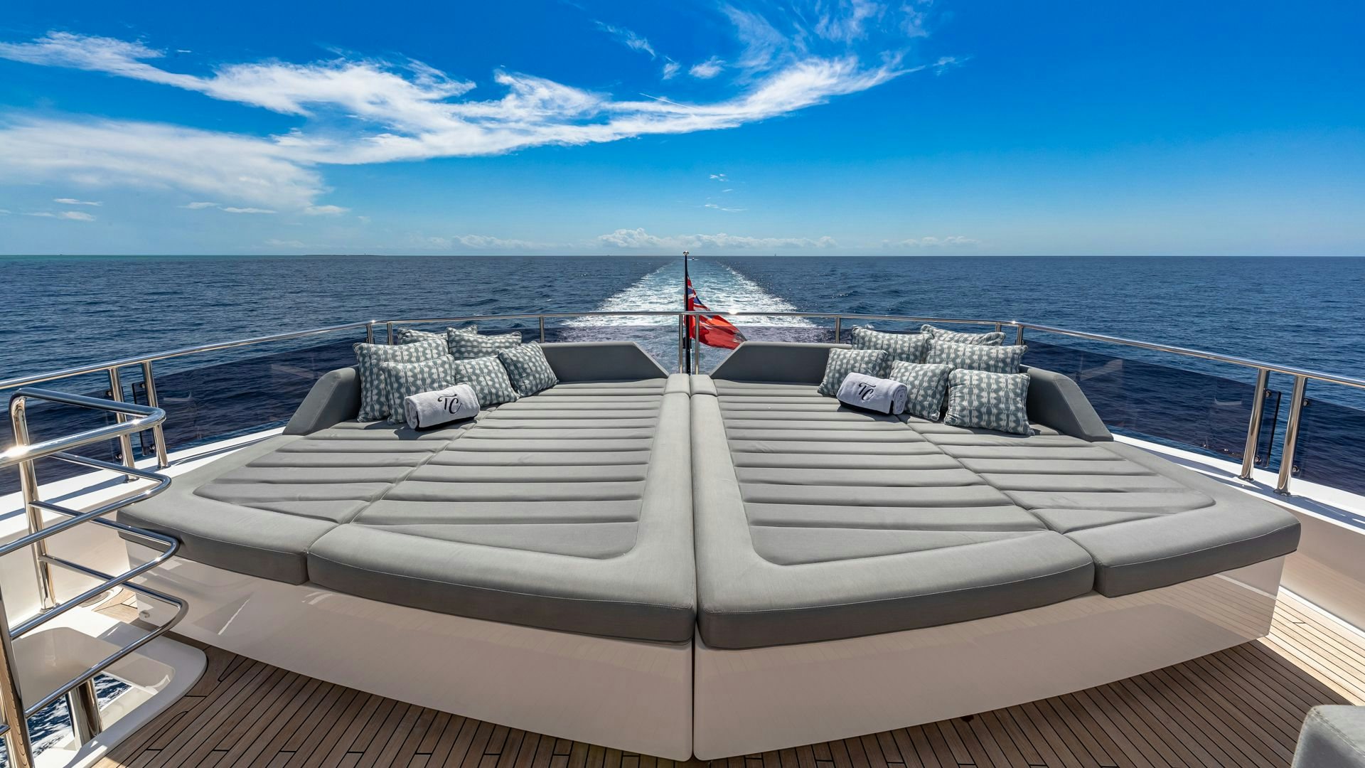 a deck with pillows and blankets on it and a flag on it aboard CAPTAIN MORGAN III Yacht for Sale