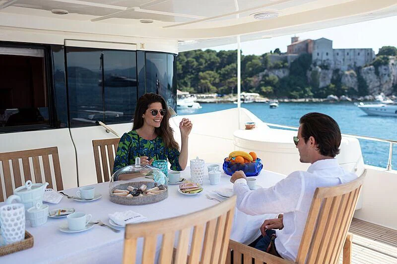 a man and woman sitting at a table with food on it aboard BEST OFF Yacht for Charter