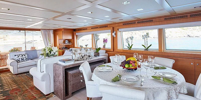 a large dining table with a white tablecloth and chairs aboard BEST OFF Yacht for Charter