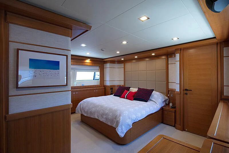 a bedroom with a bed and a wood cabinet aboard BEST OFF Yacht for Charter