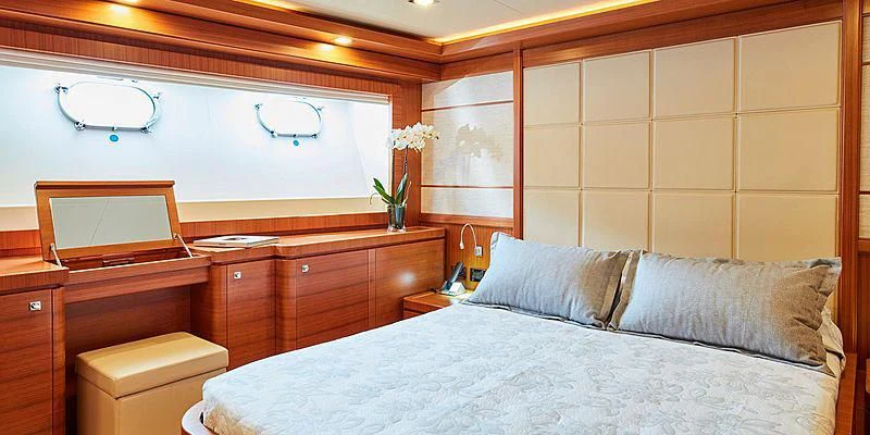 a bedroom with a bed and a dresser aboard BEST OFF Yacht for Charter