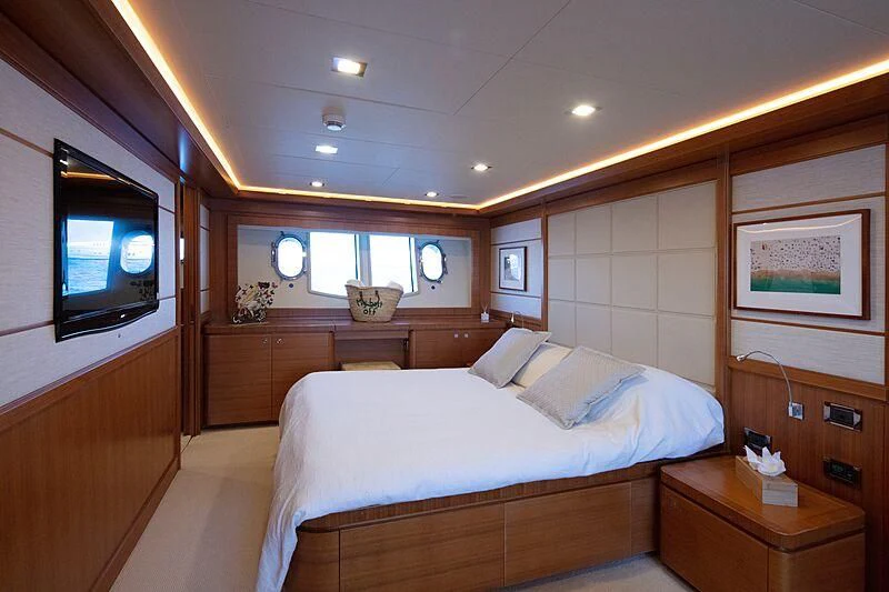 a bedroom with a bed and a tv aboard BEST OFF Yacht for Charter