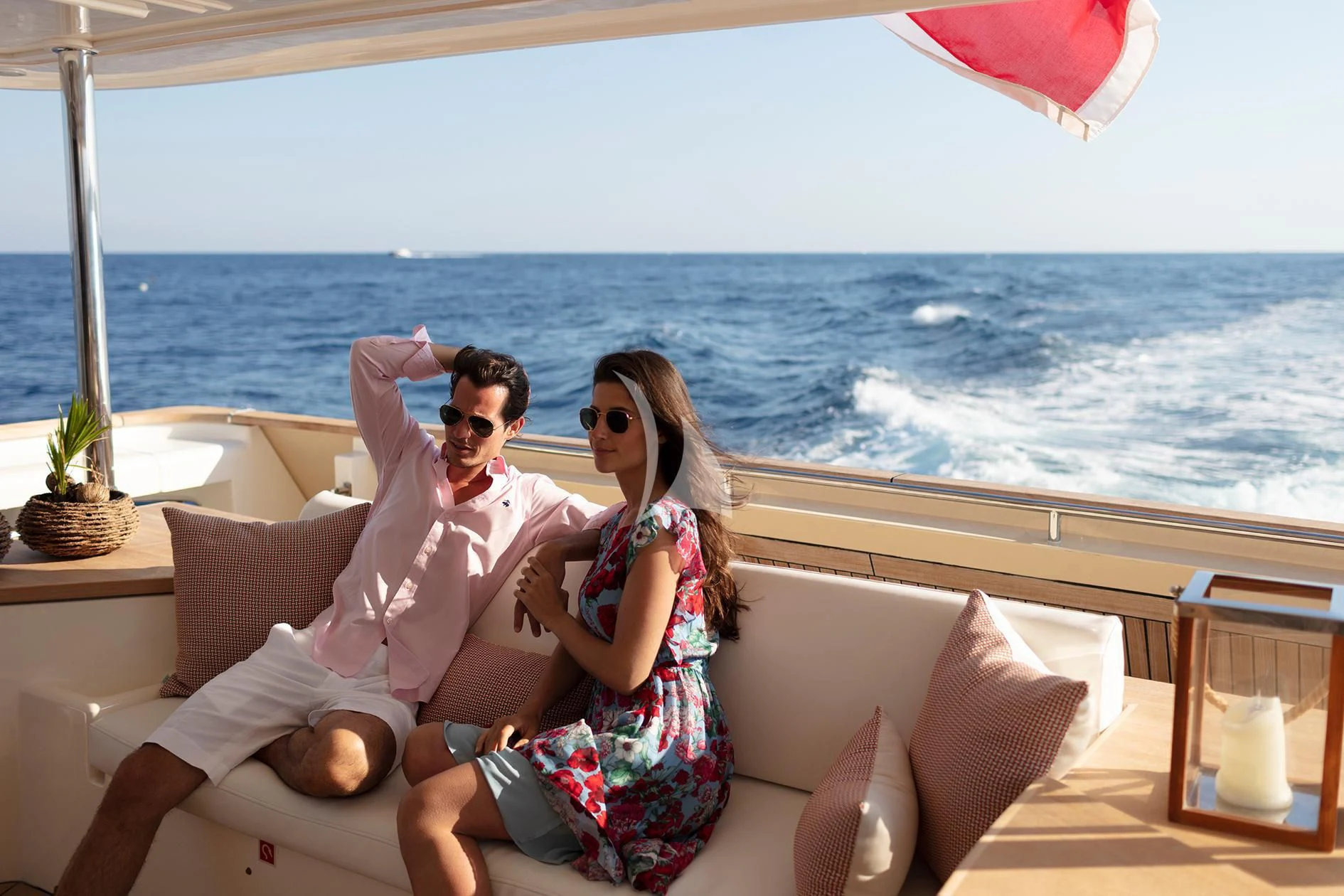 a man and woman sitting on a couch on a beach aboard BEST OFF Yacht for Charter